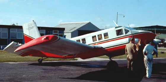 A red and white plane sitting on top of an airport runway.
