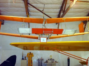 A yellow and orange plane hanging from the ceiling.