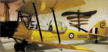 A yellow airplane with propellers hanging from the ceiling.
