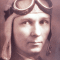 A man wearing an old fashioned pilot 's hat and goggles.