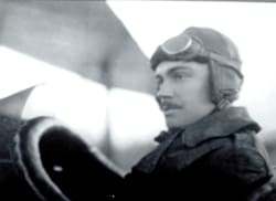 A man in uniform standing next to an airplane.