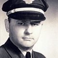 A man in uniform wearing a hat and tie.