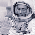 A man in an astronaut suit is sitting down.