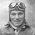 A man in an old photo wearing a helmet and goggles.